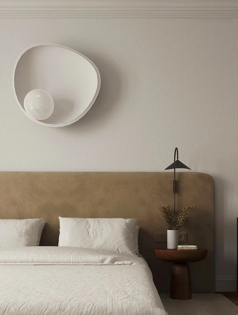 спальня с настенным светильником над кроватью